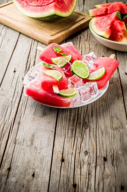 Dilimli karpuz ve nane, beyaz mermer zemin kopya alanı ile tatlı yaz karpuz ve kireç popsicles