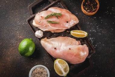 Çiğ et, ızgara veya Barbekü için hazır tavuk göğüs fileto, zeytin yağı, otlar ve baharatlar karanlık paslı arka planda, kopya alanı Üstten Görünüm