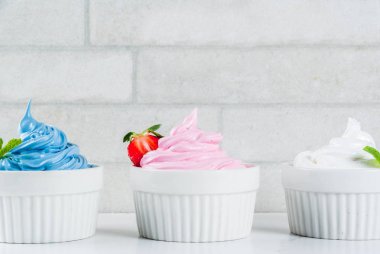 Sağlıklı beslenme yaz tatlı, vanilya ve berry donmuş yoğurt veya yumuşak kıvamlı dondurma beyaz kase, beyaz mermer arka planda kopyalama alanı