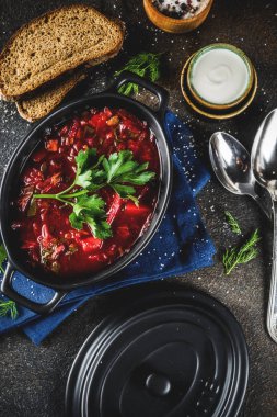 Ukraynalı Rus geleneksel sıcak yemek - Yeşiller, sarımsak, çavdar ekmeği, karanlık bir tablo ile borsch çorbası,