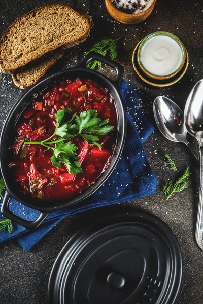 Ukraynalı Rus geleneksel sıcak yemek - Yeşiller, sarımsak, çavdar ekmeği, karanlık bir tablo ile borsch çorbası,