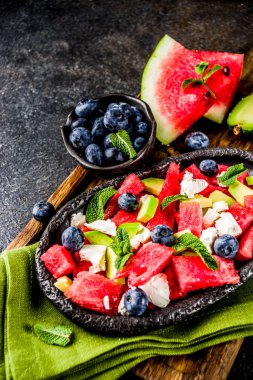 Yaz gıda kavramı, beyaz peynir, yaban mersini, avokado ve nane, karanlık paslı arka plan kopya alanı ile taze soğuk karpuz salatası