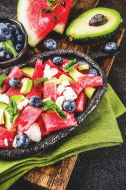 Yaz gıda kavramı, beyaz peynir, yaban mersini, avokado ve nane, karanlık paslı arka plan kopya alanı ile taze soğuk karpuz salatası