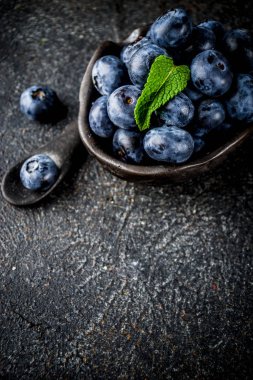 Ham taze yaban mersini küçük siyah kase, karanlık paslı arka plan kopya alanı