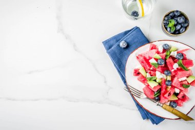Yaz gıda kavramı, beyaz peynir, yaban mersini, avokado ve nane, beyaz mermer zemin kopya alanı ile taze soğuk karpuz salatası