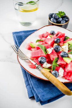 Yaz gıda kavramı, beyaz peynir, yaban mersini, avokado ve nane, beyaz mermer zemin kopya alanı ile taze soğuk karpuz salatası