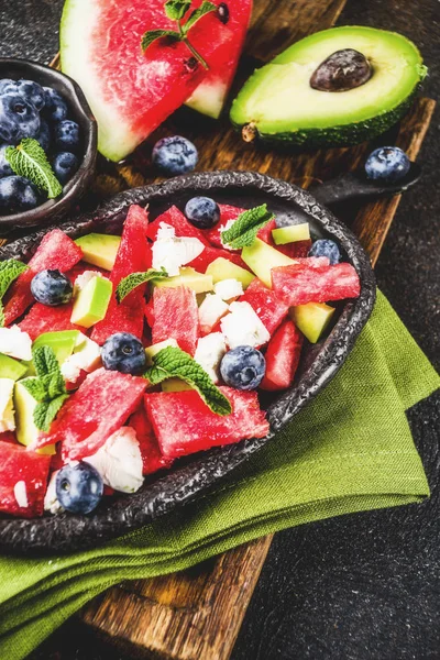 Yaz gıda kavramı, beyaz peynir, yaban mersini, avokado ve nane, karanlık paslı arka plan kopya alanı ile taze soğuk karpuz salatası