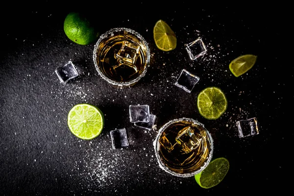 Dois Copos Tequila Fundo Escuro Com Cubos Gelo Sal Limas — Fotografia de Stock