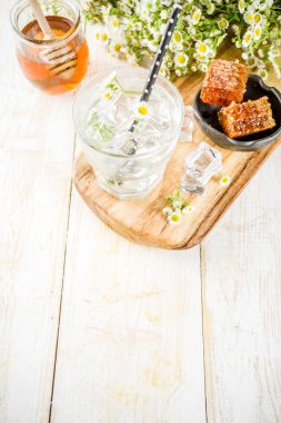 Organik diyet detoks yaz İçecek, papatya ve ballı papatya çiçeği ve bir kavanoz bal ile beyaz tahta masada su içki infüzyon. Kopya alanı