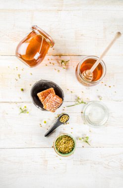 Organik çiçek bal, kavanoz, bir masada Beyaz ahşap, kır çiçekleri, polen ve bal tarak ile kopyalama alanı üstten görünüm