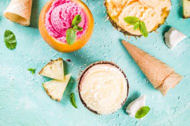 Yaz tatil tatil kavramı, ananas, greyfurt ve Hindistan cevizi çeşitli tropikal dondurma sorbets, donmuş suları ayarla, mavi beton arka plan kopya alanı ışık