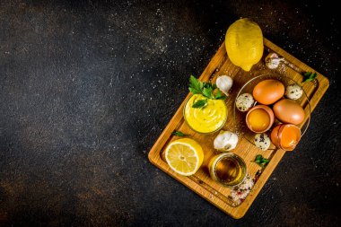 Ev yapımı mayonez sos malzemeler - limon, yumurta, zeytinyağı, baharat ve otlar, siyah beton arka plan kopya alanı ile