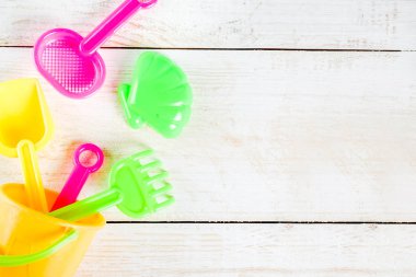 Yaz tatil kavramı ile plastik beach çocuklar oyuncak - kepçe, kepçe, Komisyon, kalıpları tekne, lifebuoy oyuncaklar alan beyaz ahşap arka plan yukarıdaki kopyalayın.
