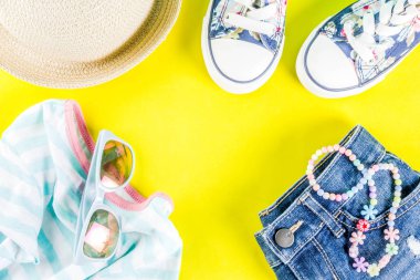 Yaz tatil kavramı, yaz çocuk bezi seti - çocuklar şort, tişört, şapka, güneş gözlüğü, bilezik kolye, spor ayakkabıları, parlak sarı arka plan düz yatıyordu kopya alanı üstüne