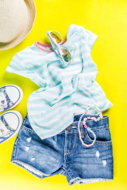 Yaz tatil kavramı, yaz çocuk bezi seti - çocuklar şort, tişört, şapka, güneş gözlüğü, bilezik kolye, spor ayakkabıları, parlak sarı arka plan düz yatıyordu kopya alanı üstüne