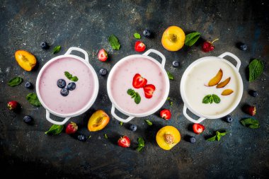 Çeşitli tatlı krem meyve ve berry Çorbalar - çilek, şeftali, yaban mersini, koyu mavi beton arka plan üstten görünüm kopya alanı