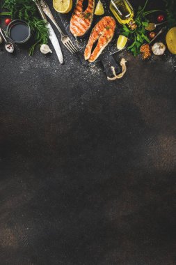 Izgara Somon Balık biftek malzemeler limon, otlar, zeytin yağı, kayrak kesme tahtası, karanlık paslı arka plan kopya alanı ile