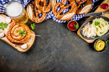 Oktoberfest yemek menüsü, çubuk kraker ile Bavyera sosis püre patates, lahana turşusu, bira şişesi ve kupa, karanlık paslı arka plan kopya alanı üstten görünüm