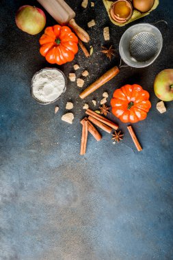Tatlı sonbahar fırın pişirme arka plan ile un, oklava, dekoratif kabak, elma, tarçın anason kakule şekerle baharatlar. Koyu mavi paslı arka plan üstten görünüm kopya alanı
