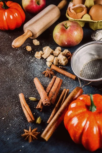 Tatlı sonbahar fırın pişirme arka plan ile un, oklava, dekoratif kabak, elma, tarçın anason kakule şekerle baharatlar. Koyu mavi paslı arka plan üstten görünüm kopya alanı