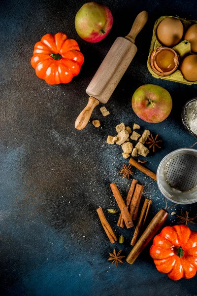 Tatlı sonbahar fırın pişirme arka plan ile un, oklava, dekoratif kabak, elma, tarçın anason kakule şekerle baharatlar. Koyu mavi paslı arka plan üstten görünüm kopya alanı