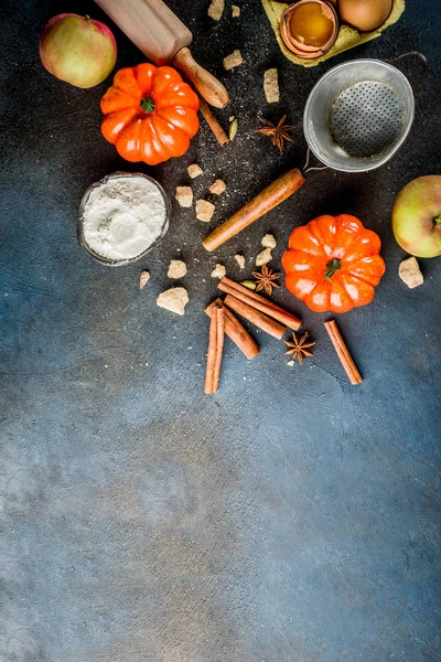 Tatlı sonbahar fırın pişirme arka plan ile un, oklava, dekoratif kabak, elma, tarçın anason kakule şekerle baharatlar. Koyu mavi paslı arka plan üstten görünüm kopya alanı