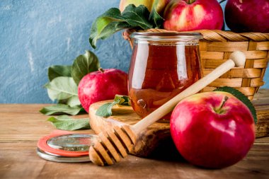 Yahudi tatil Rosh Hashanah ya da elma Bayramı gün konseptiyle, kırmızı elma, elma yaprakları ve bal kavanozuna, açık mavi ve ahşap renkli kopya alanı