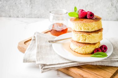 Trendy Asya gıda, kabarık Japonya sufle krep, hotcakes akçaağaç şurubu ve ahududu açık beton arka planı ile alanı Kopyala