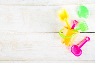 Yaz tatil kavramı ile plastik beach çocuklar oyuncak - kepçe, kepçe, Komisyon, kalıpları tekne, lifebuoy oyuncaklar alan beyaz ahşap arka plan yukarıdaki kopyalayın.