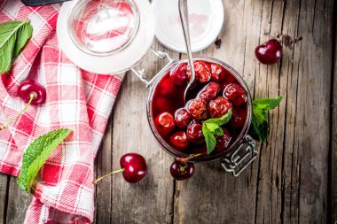 Ev yapımı taze kiraz rustik eski ahşap arka plan kopya alanı yukarıdaki tarih ile kiraz ve nane reçel korunmuş