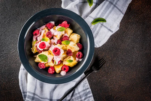 Ukrayna, Rus gıda, tembel vareniki; Lor veya peynirli gnocchi taze çiğ ahududu, krem ve karanlık bir beton zemin üzerine nane ile uzay üstten görünüm Kopyala