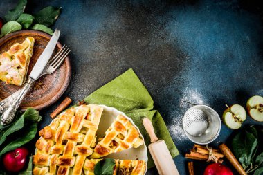 Geleneksel sonbahar pişirme, ev yapımı elma pasta ile tarçın, koyu mavi arka plan ile çalışırken rulo, pudra şekeri, taze elma, baharatlar, alan üst görünüm Kopyala