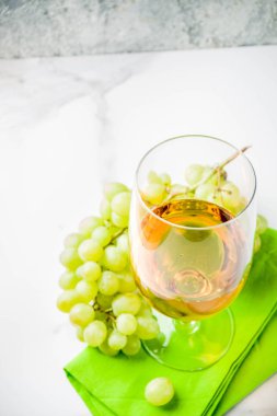 Üzüm, mermer bir beyaz tablo kopya alanı bir dalı ile beyaz şarap kadehi