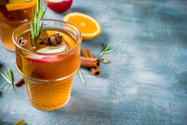 Geleneksel kış içki içer, mulled şarap kokteyli ile baharat, elma, portakal, beyaz şarap. Üzerinde mavi masa lambası,