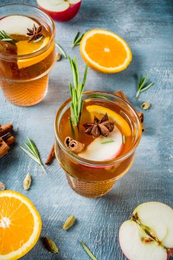 Geleneksel kış içki içer, mulled şarap kokteyli ile baharat, elma, portakal, beyaz şarap. Üzerinde mavi masa lambası,