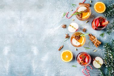 Geleneksel kış içecekler, beyaz ve kırmızı mulled şarap kokteyl ile beyaz ve kırmızı şarap, baharat, elma, portakal. Üzerinde mavi masa lambası,