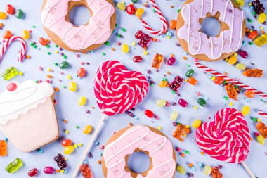 Tatlılar yaratıcı paralamak, lolipop, reçel, şeker, çerezleri çörek ve cupcakes, açık mavi renkli üstten görünüm kopya alanı ile tatlı kavramı