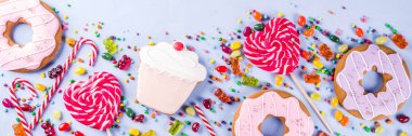 Tatlılar yaratıcı paralamak, tatlı konseptiyle lolipop, reçel, şeker, çerezleri çörek ve cupcakes, açık mavi renkli üstten görünüm kopya alanı başlık biçimi