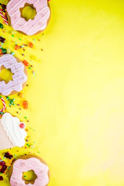 Tatlılar yaratıcı paralamak, lolipop, reçel, şeker, çerezleri çörek ve cupcakes, parlak sarı arka plana üstten görünüm kopya alanı ile tatlı kavramı