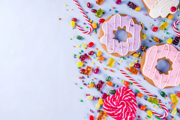 Tatlılar yaratıcı paralamak, lolipop, reçel, şeker, çerezleri çörek ve cupcakes, parlak sarı arka plana üstten görünüm kopya alanı ile tatlı kavramı