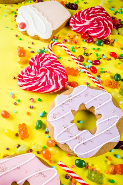 Tatlılar yaratıcı paralamak, lolipop, reçel, şeker, çerezleri çörek ve cupcakes, parlak sarı arka plana üstten görünüm kopya alanı ile tatlı kavramı