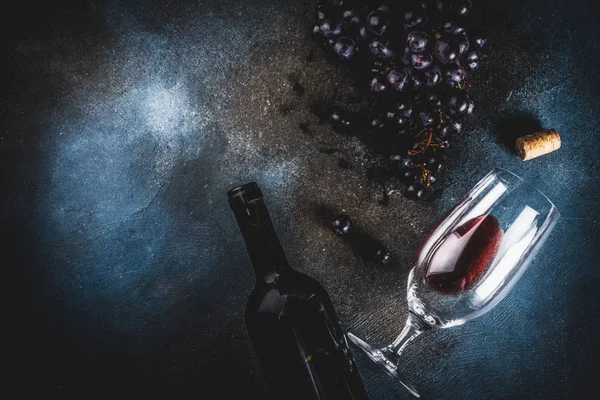 Cam ve üzüm ile kırmızı şarap şişesi, koyu arka plan kopya alanı üstten görünüm seçici odak