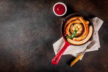 Ev yapımı ızgara biftek ve ketçap, koyu arka plan kopya alanı yukarıdaki ile kırmızı dökme demir tavada tavuk sosis