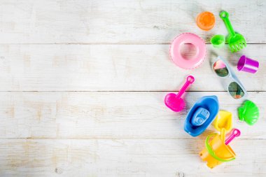 Yaz tatil kavramı ile plastik beach çocuklar oyuncak - kepçe, kepçe, Komisyon, kalıpları tekne, lifebuoy oyuncaklar alan beyaz ahşap arka plan yukarıdaki kopyalayın.