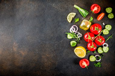 Yemek arka plan, taze salata malzemeleri, İtalyan mutfağı - Domates, zeytin yağı, limon, salatalık, roka, maydanoz, soğan, karanlık paslı arka plan kopya alanı üstten görünüm