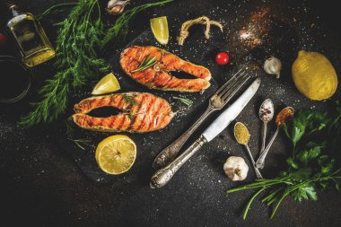 Izgara Somon Balık biftek malzemeler limon, otlar, zeytin yağı, kayrak kesme tahtası, karanlık paslı arka plan kopya alanı ile
