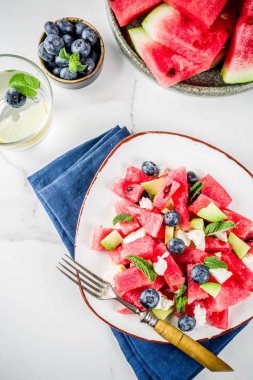 Yaz gıda kavramı, beyaz peynir, yaban mersini, avokado ve nane, beyaz mermer zemin kopya alanı ile taze soğuk karpuz salatası