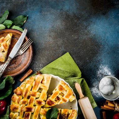 Geleneksel sonbahar pişirme, ev yapımı elma pasta ile tarçın, koyu mavi arka plan ile çalışırken rulo, pudra şekeri, taze elma, baharatlar, alan üst görünüm Kopyala