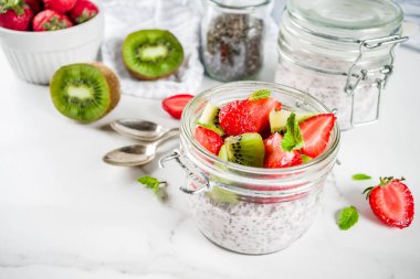 Sağlıklı diyet vejetaryen kahvaltı, chia tohum ve taze meyve, çilek, kivi ile yoğurt. Beyaz mermer zemin kopya alanı