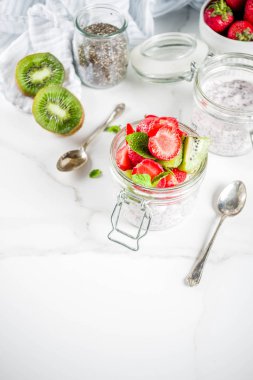 Sağlıklı diyet vejetaryen kahvaltı, chia tohum ve taze meyve, çilek, kivi ile yoğurt. Beyaz mermer zemin kopya alanı